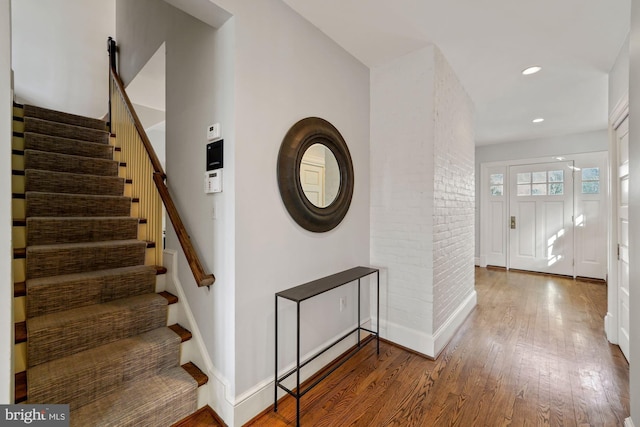 interior space with hardwood / wood-style floors and brick wall