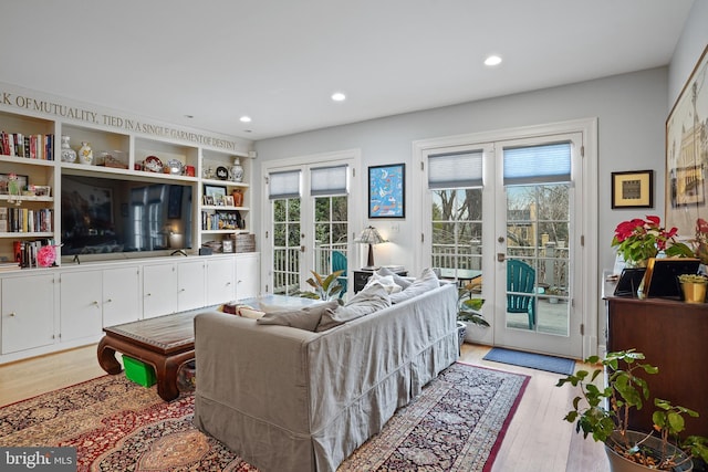 living room with french doors and light hardwood / wood-style flooring