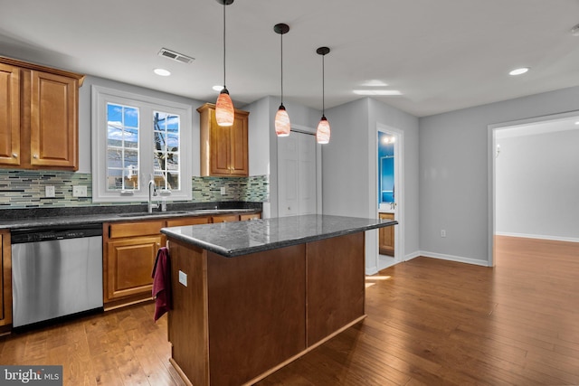 kitchen featuring a kitchen island, pendant lighting, sink, stainless steel dishwasher, and dark wood-type flooring