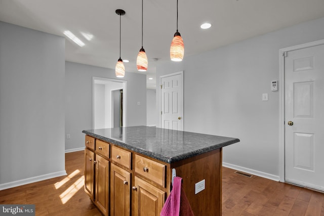 kitchen featuring dark hardwood / wood-style flooring, hanging light fixtures, and a kitchen island