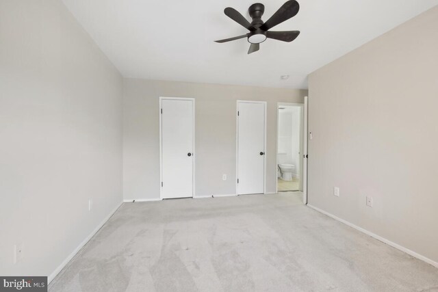 unfurnished bedroom featuring light colored carpet and ensuite bath