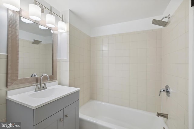 bathroom featuring tiled shower / bath and vanity