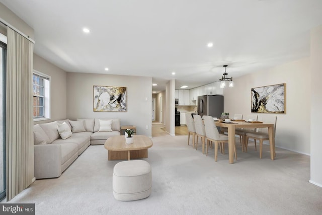 living room with an inviting chandelier and light colored carpet