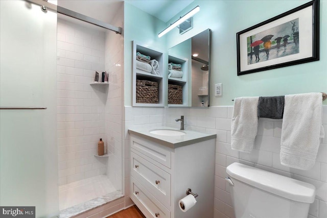 bathroom with tiled shower, tile walls, and toilet