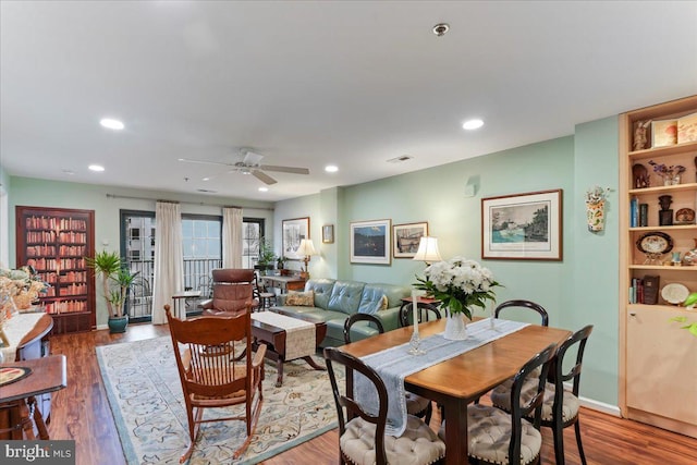 dining room with baseboards, wood finished floors, and recessed lighting