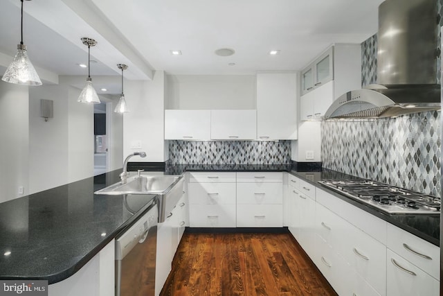 kitchen with stainless steel appliances, white cabinetry, pendant lighting, and wall chimney range hood