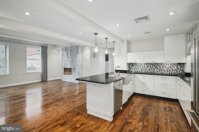 kitchen with sink, dishwasher, white cabinetry, decorative light fixtures, and kitchen peninsula