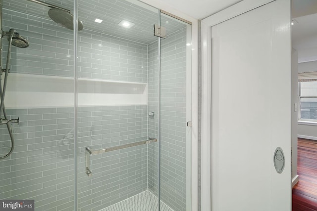 bathroom with hardwood / wood-style floors and an enclosed shower