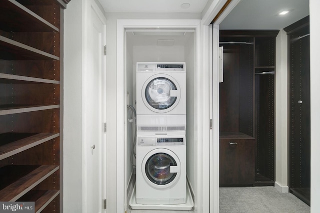 clothes washing area with stacked washer / drying machine and carpet floors