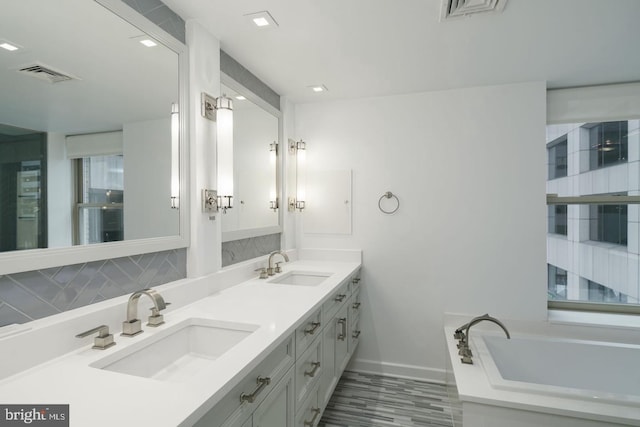 bathroom with vanity, a bathtub, and decorative backsplash