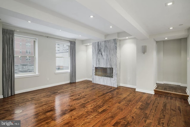 unfurnished living room with dark hardwood / wood-style flooring, a fireplace, and beam ceiling