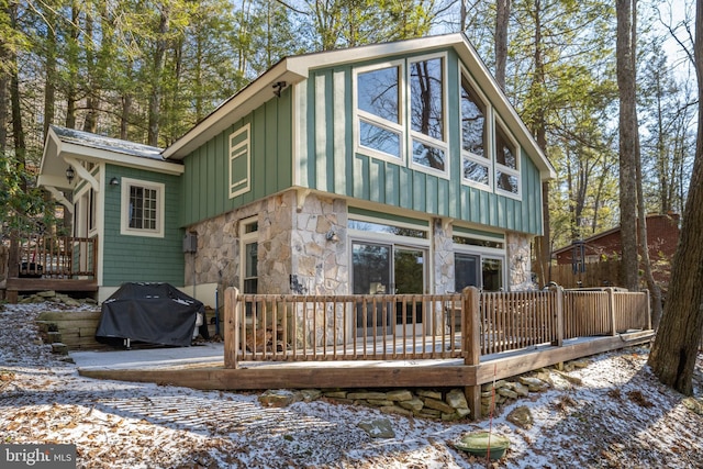 3084 Lake Shore Dr, Oakland, MD 21550 - snow covered rear of property featuring board and batten siding, stone siding, and a deck