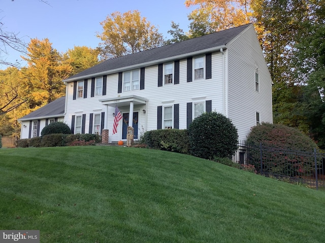 colonial inspired home featuring a front lawn