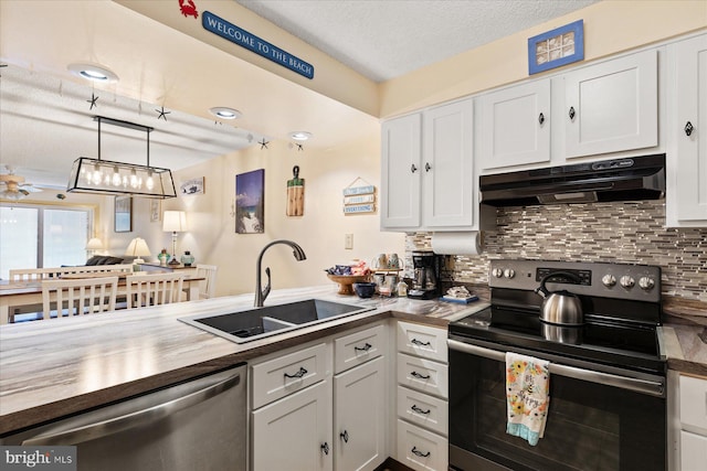 kitchen with appliances with stainless steel finishes, decorative light fixtures, white cabinetry, sink, and backsplash