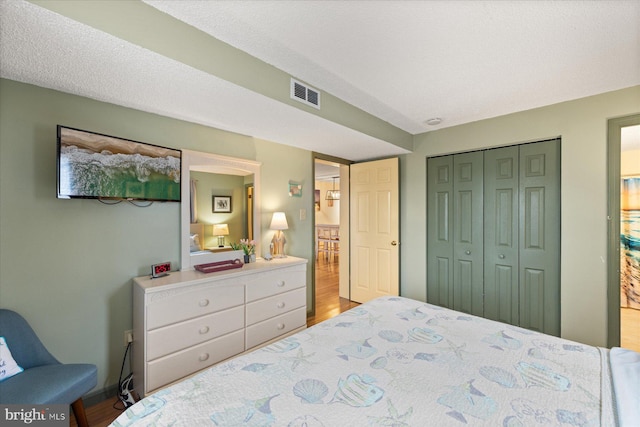 bedroom featuring hardwood / wood-style floors, a closet, and a textured ceiling