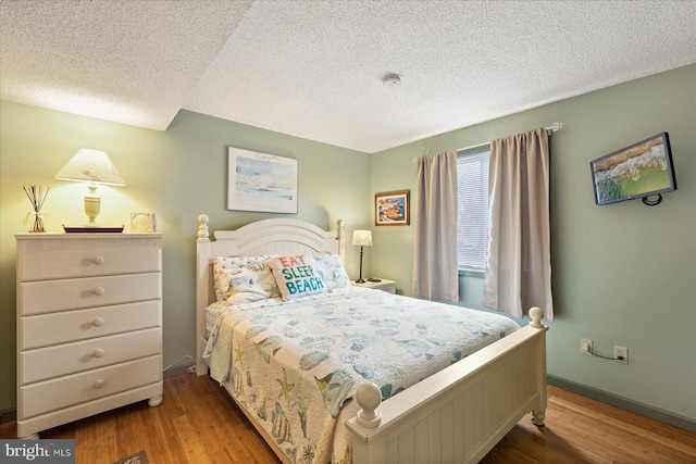 bedroom featuring a textured ceiling and light hardwood / wood-style flooring