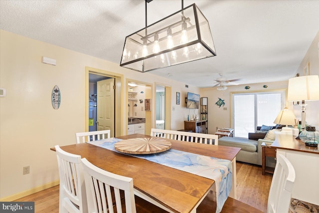 dining area featuring ceiling fan, a textured ceiling, and light wood-type flooring