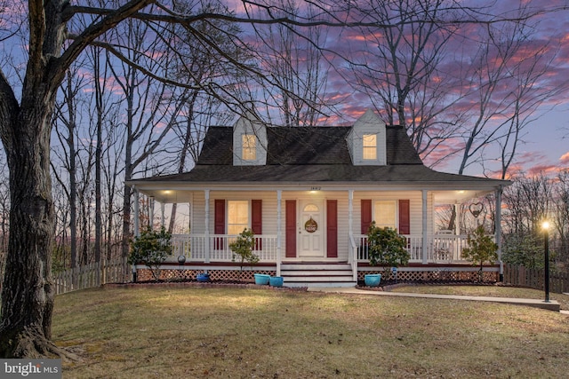 farmhouse inspired home featuring roof with shingles, covered porch, and a front lawn