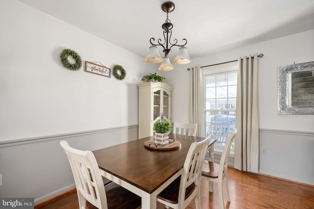 dining room with wood finished floors, baseboards, and a chandelier