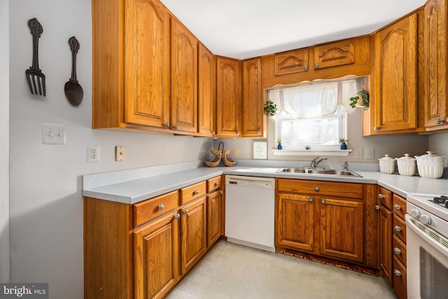 kitchen featuring a sink, white appliances, and brown cabinets