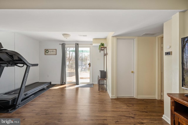 workout area featuring visible vents, wood finished floors, and baseboards