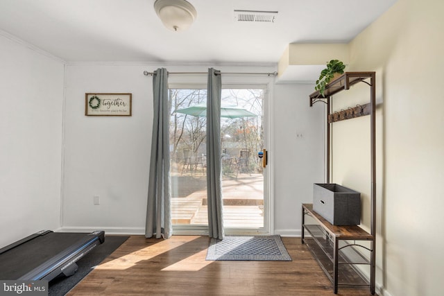 doorway to outside with visible vents, baseboards, and wood finished floors