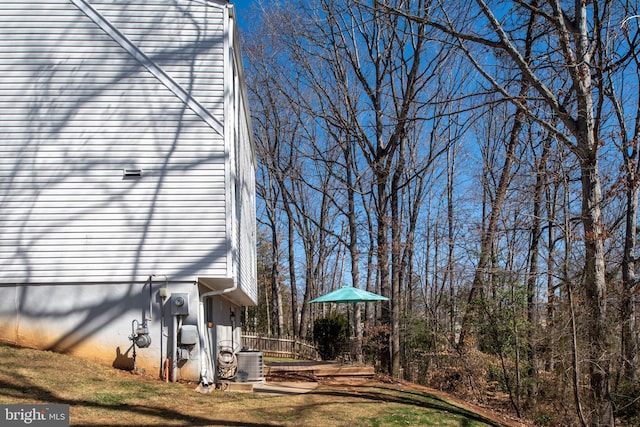 view of side of property with a lawn and central AC