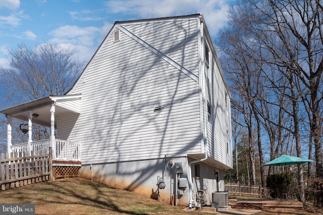 view of side of home featuring central air condition unit and fence