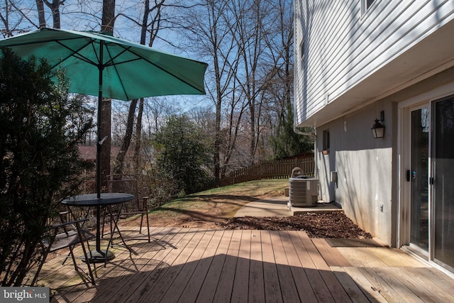 deck with cooling unit, outdoor dining space, and fence