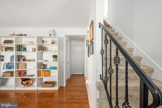 hall with stairway, baseboards, and wood finished floors