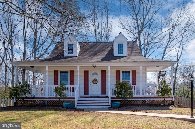 farmhouse inspired home with a porch, fence, and a front yard