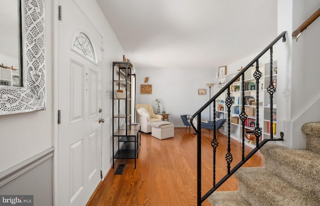 foyer entrance with stairway, visible vents, and wood finished floors