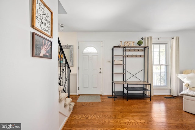 entrance foyer with stairway, wood finished floors, and baseboards