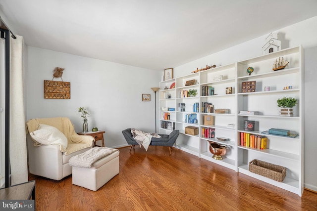 living area with baseboards and wood finished floors