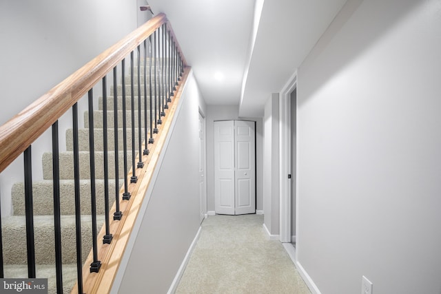 hallway with light colored carpet and baseboards