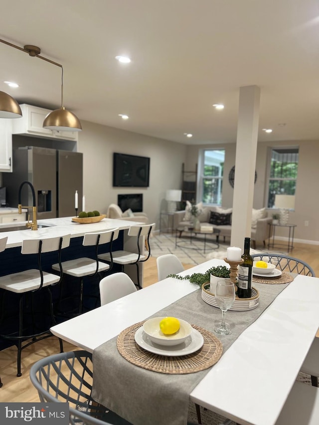 dining space featuring light wood-style floors, recessed lighting, a healthy amount of sunlight, and baseboards