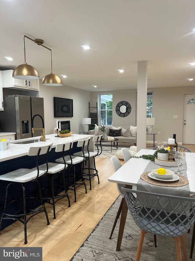 dining space with light wood finished floors and recessed lighting