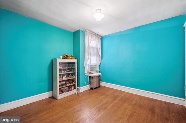 interior space featuring radiator heating unit, beverage cooler, and hardwood / wood-style floors