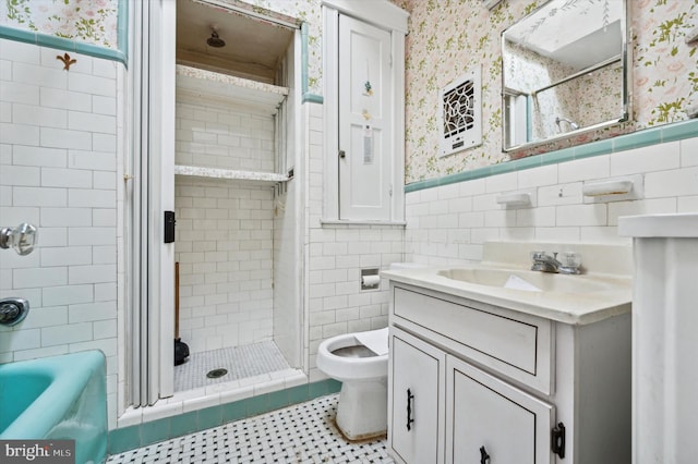 bathroom featuring vanity, tiled shower, and tile walls