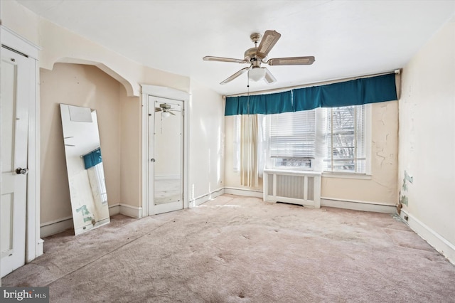 unfurnished bedroom featuring ceiling fan, carpet flooring, and radiator