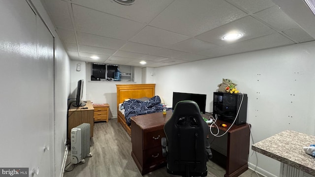 bedroom with a drop ceiling and hardwood / wood-style flooring