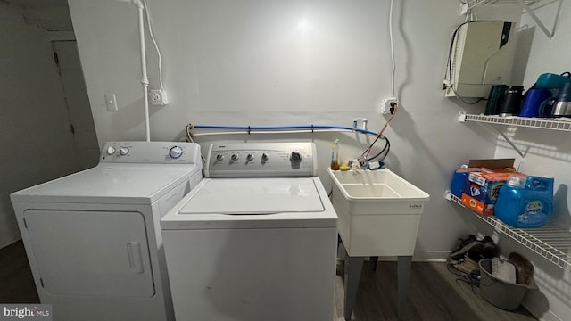 washroom with sink, dark wood-type flooring, and washing machine and clothes dryer