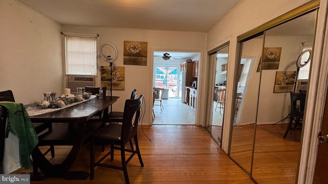 dining area featuring cooling unit and wood-type flooring