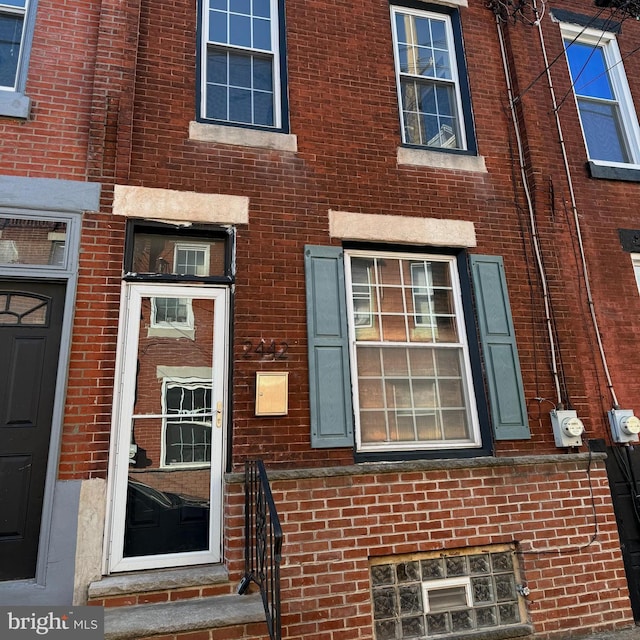 view of exterior entry featuring brick siding