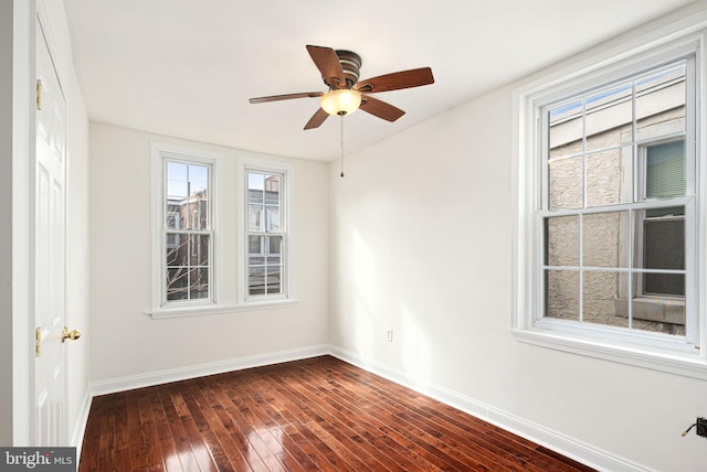 unfurnished room with ceiling fan, dark wood-style flooring, and baseboards