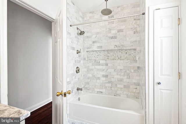 bathroom with baseboards, wood finished floors, a closet, and a combined bath / shower with rainfall shower