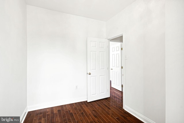 empty room featuring dark wood finished floors and baseboards