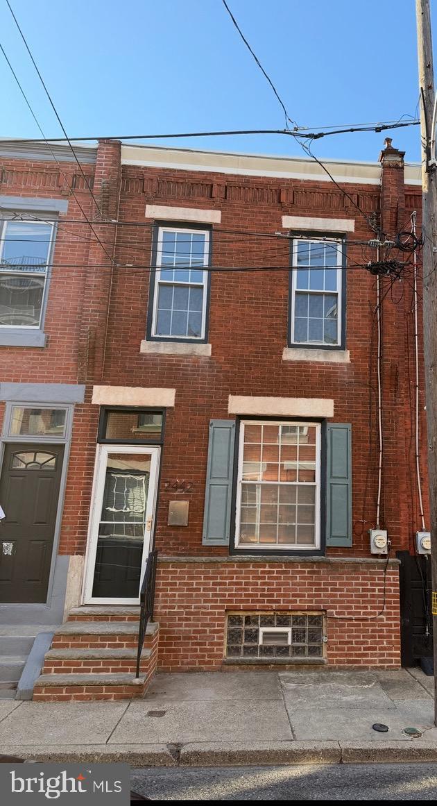 view of property featuring entry steps and brick siding