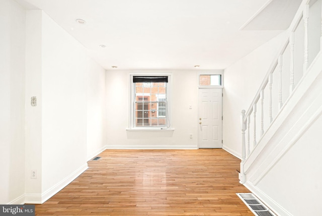 entrance foyer with stairs, baseboards, visible vents, and light wood-style floors