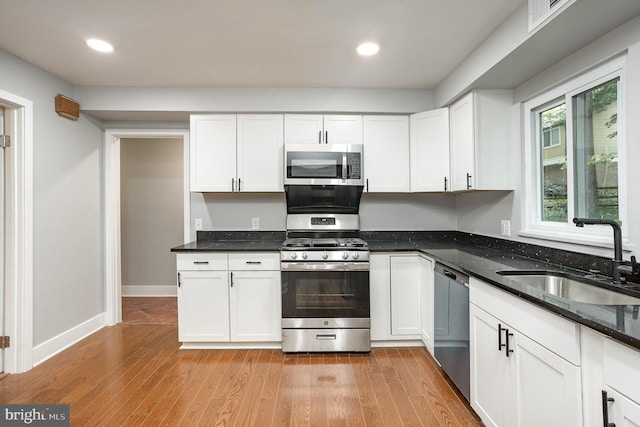 kitchen with stainless steel appliances, sink, and white cabinets